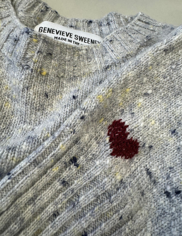 Close-up of a textured fabric with a red stain and Genevieve Sweeney label.