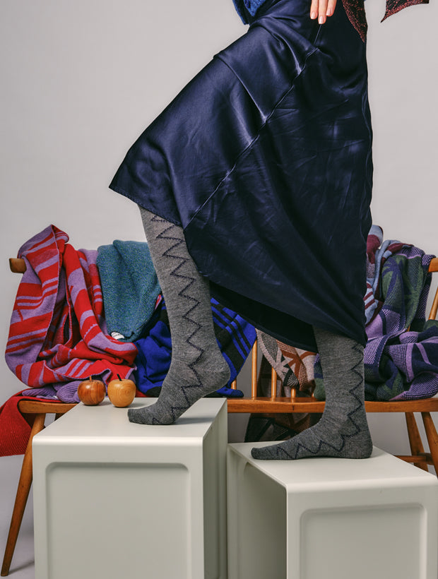 woman wearing Sia Merino Knee High Grey Socks in Navy styled with navy blue silk dress